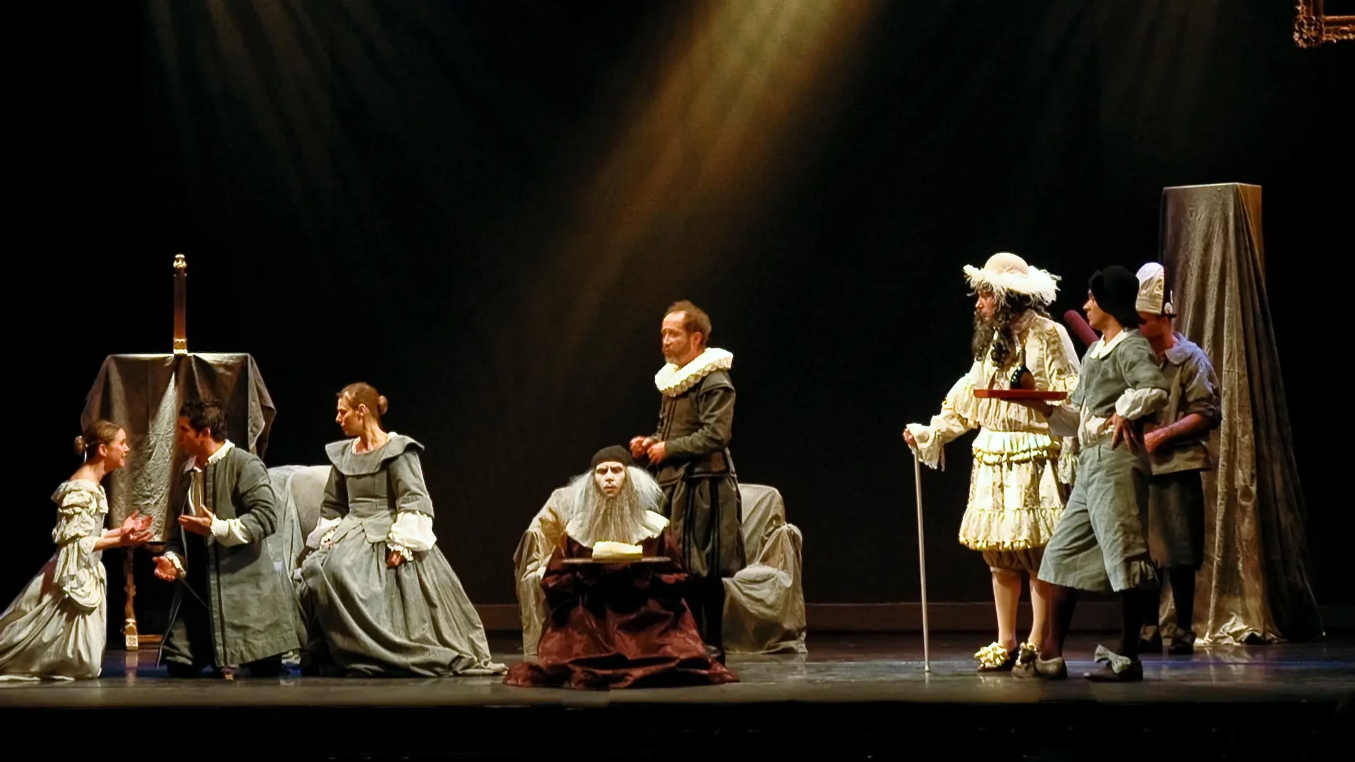 Deux des comédiens en costume d'époque. Ils tiennent tout deux une caissette qu'ils se disputent.