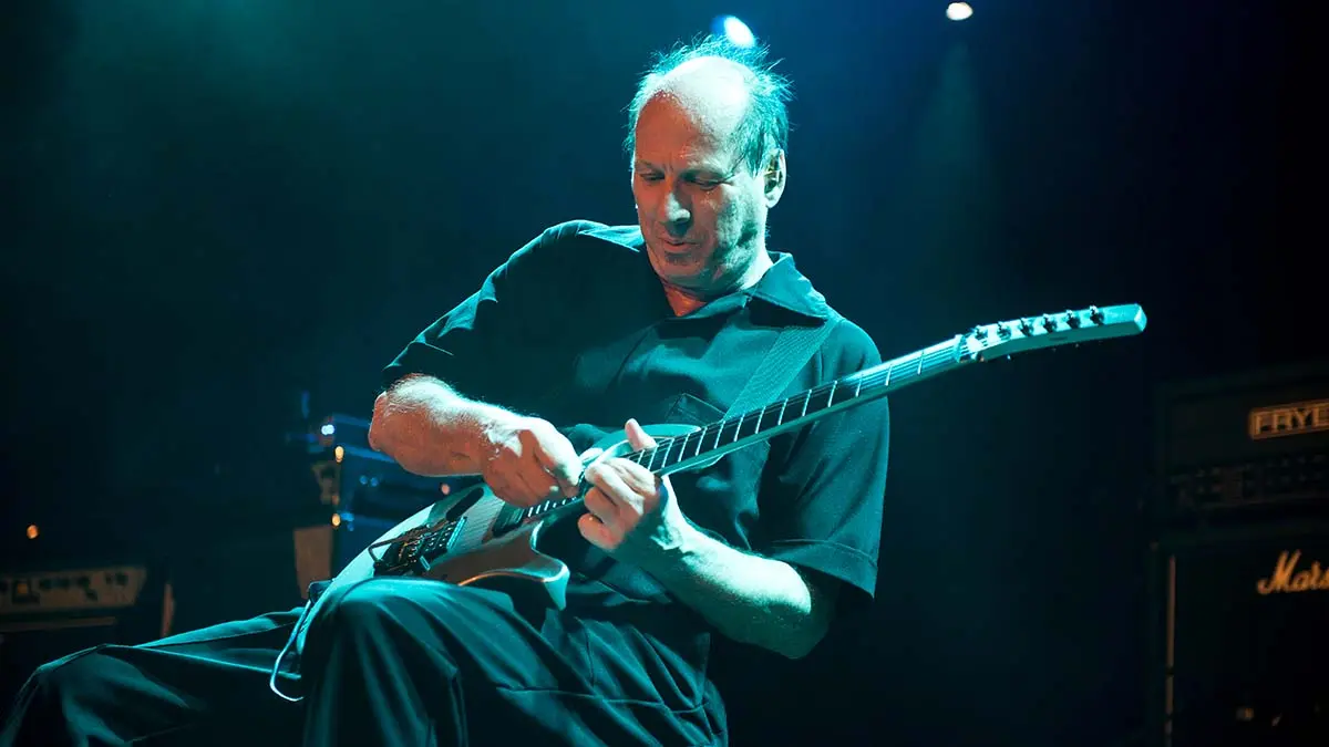 Adrian Belew sur scène, il joue de la guitare.