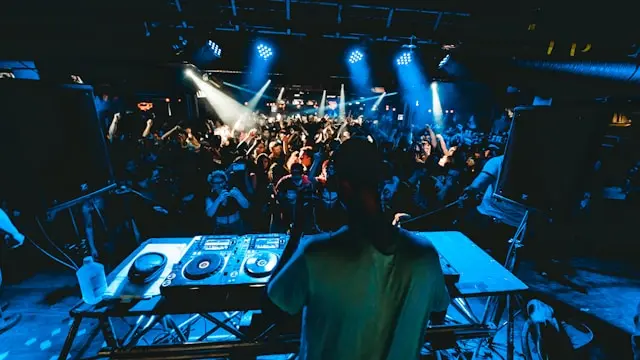 Le Dj de dos devant ses platines, il fait face au public.